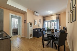 A modern living room with a dining area, a sofa, a coffee table, and a TV.