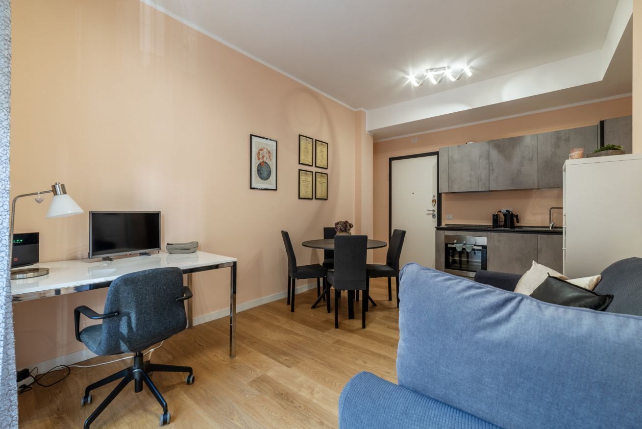 A modern apartment with a dining area, kitchenette, and a living room with a sofa.