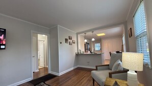 Un salon avec un canapé, une table basse et un téléviseur fixé au mur.