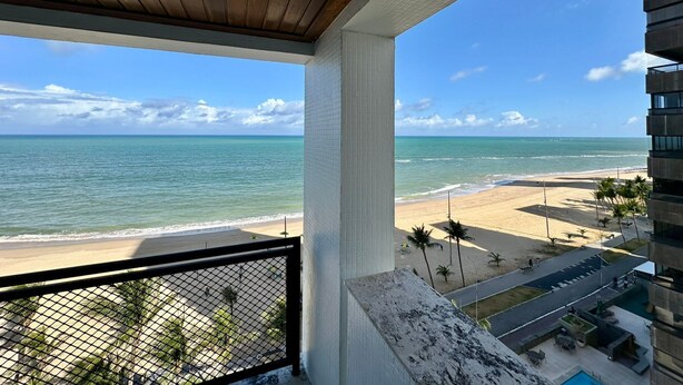 Ein Balkon mit Blick auf Strand und Meer.
