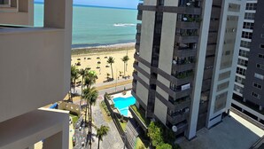 Ein Hochhaus mit Balkonen, einem Pool und Blick auf den Strand.