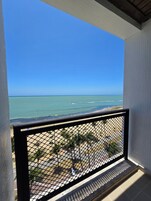 Uma varanda com vista para a praia e o oceano.