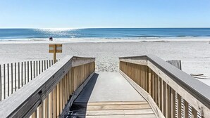 Un muelle de madera que conduce a una playa con cielo despejado.