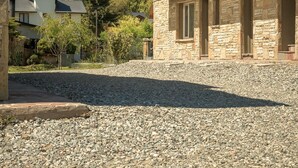 A stone building with a balcony, a clear sky, and a person paragliding in the background. - Luna Azul. Condo. Fast Wifi. Free Parking. (San Carlos de Bariloche)