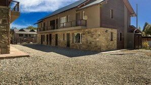 A two-story house with a stone facade, a balcony, and a chimney. - Luna Azul. Condo. Fast Wifi. Free Parking. (San Carlos de Bariloche)