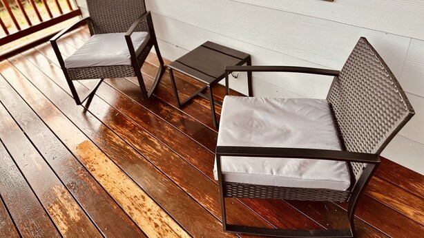 A wooden deck with two wicker chairs and a small table. - New, Fun-Size Benbow House! (Garberville)