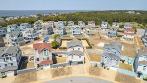 A residential area with multiple two-story houses, a playground, and a clear view of the ocean. - Oceanside, Hot Tub, Community Pool, CB51, OBXcape (Corolla)