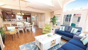 A spacious living area with a dining table, chairs, a sofa, and a coffee table. - Oceanside, Hot Tub, Community Pool, CB51, OBXcape (Corolla)
