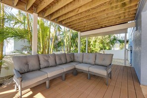 A covered outdoor seating area with a sectional sofa.