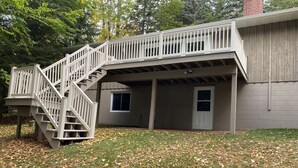 A two-story house with a wooden staircase leading to a balcony. - Lake Lucerne Family Getaway, private setting close to town (Crandon)
