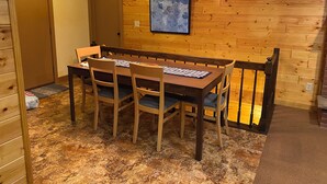 A dining area with a wooden table and chairs, a chandelier, and a painting on the wall. - Lake Lucerne Family Getaway, private setting close to town (Crandon)
