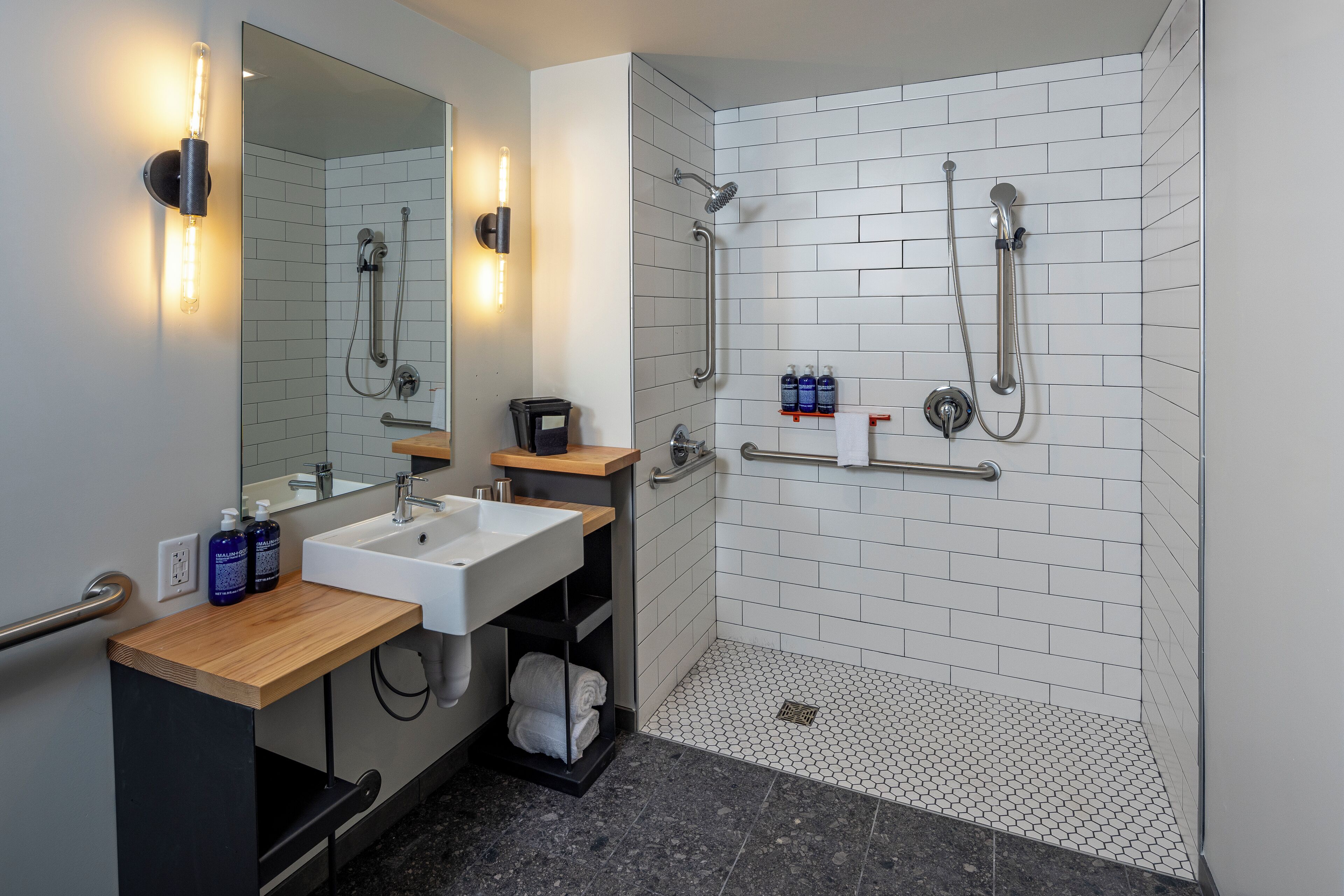A modern bathroom with a sink, mirror, and shower.