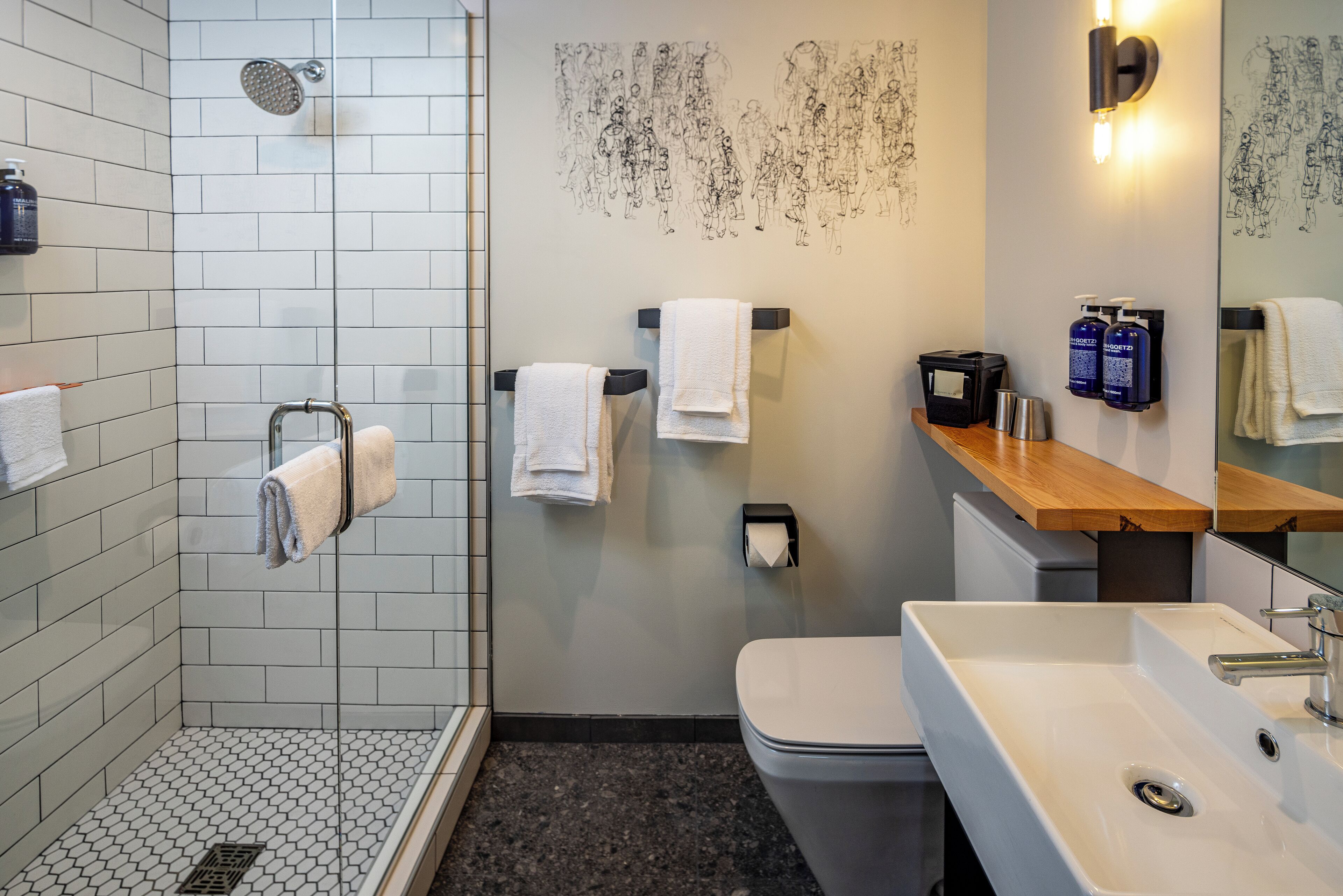 A modern bathroom with a shower, toilet, and sink.