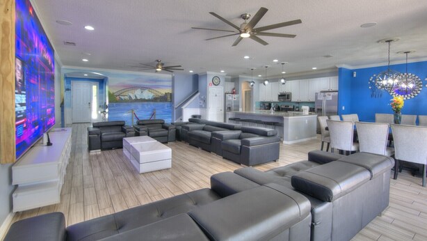 A modern living room with a large sectional sofa, a flat-screen TV, and a ceiling fan. - Amazing Bowling Alley Home, Orlando Mansion 6223 (Orlando)