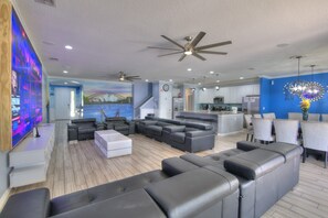 A modern living room with a large sectional sofa, a flat-screen TV, and a ceiling fan. - Amazing Bowling Alley Home, Orlando Mansion 6223 (Orlando)