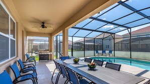 A covered patio with a pool, outdoor seating, and a grill area. - Amazing Bowling Alley Home, Orlando Mansion 6223 (Orlando)