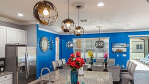 A modern kitchen with granite countertops, stainless steel appliances, and a central island with a vase of flowers. - Amazing Bowling Alley Home, Orlando Mansion 6223 (Orlando)
