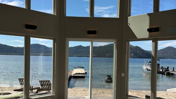 A spacious room with large windows overlooking a lake and boats. - Priest Lake Waterfront Property With Majestic Lake & Mountain Views.

 (Coolin)