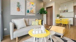 Uma sala de estar moderna com um sofá, uma mesa de centro amarela e obras de arte na parede.
