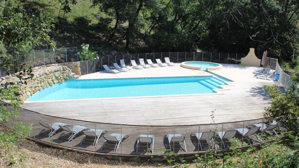 A swimming pool with multiple lanes, surrounded by lounge chairs and a wooden deck. - Saint-Michel by Interhome (Draguignan)