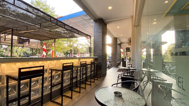 Un café en plein air avec un coin bar, des tables et des chaises.