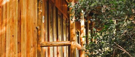 A wooden cabin with a rustic exterior, a wooden door, and a small porch area.