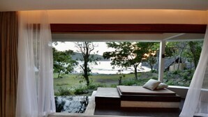 Een moderne slaapkamer met een groot raam, een bed en uitzicht op een natuurlandschap.