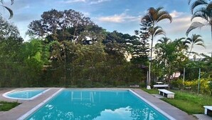 Ein rechteckiger Pool mit glasklarer, blauer Wasseroberfläche, umgeben von einer Betonplattform.