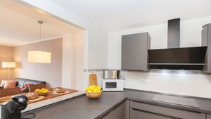 A modern kitchen with a built-in microwave, a coffee machine, and a large stove. - Les Suredes by Interhome (St Antoni de Calonge)