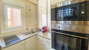 A kitchen with a built-in oven, a microwave, and a sink. - Amsterdam Playa Levante by Interhome (Benidorm)
