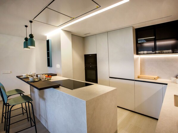 Una cucina moderna con isola centrale, elettrodomestici integrati e un design minimalista.
