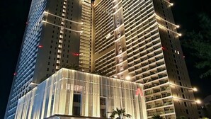 Un hôtel à plusieurs étages au design moderne, doté d’une entrée imposante avec une façade en verre et d’un grand logo en forme d’étoile rouge.