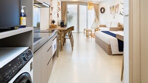 Une chambre d’hôtel moderne équipée d’un coin cuisine, d’une table à manger et d’un lit.