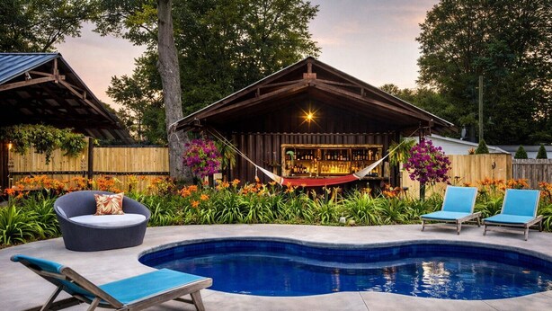 Un jardin avec une piscine, un hamac, un coin bar et des sièges d’extérieur.
