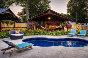 A backyard with a swimming pool, a hammock, a bar area, and outdoor seating. - Oasis Retreat: pool, hot tub, outdoor bar, & guest house. 4 blocks to downtown (South Haven)