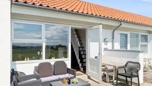 Un patio con mobiliario exterior, una mesa y una silla.