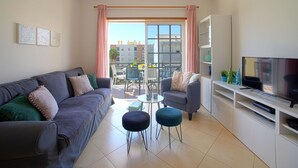 A modern living room with a grey sofa, two armchairs, a small round table, and a TV on a white cabinet. - Sunny Beach Diamond by Interhome (Armação de Pêra)