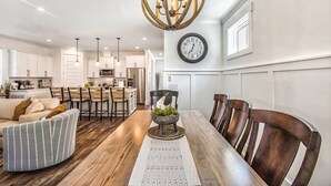 A modern kitchen with white cabinets, stainless steel appliances, and pendant lighting. - Beach, Private Pool, Designer Everything, Exclusive  Community (Hilton Head Island)