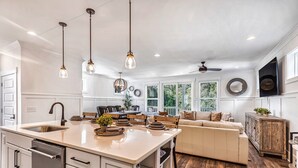 A spacious kitchen with a central island, white cabinetry, and pendant lighting. - Beach, Private Pool, Designer Everything, Exclusive  Community (Hilton Head Island)
