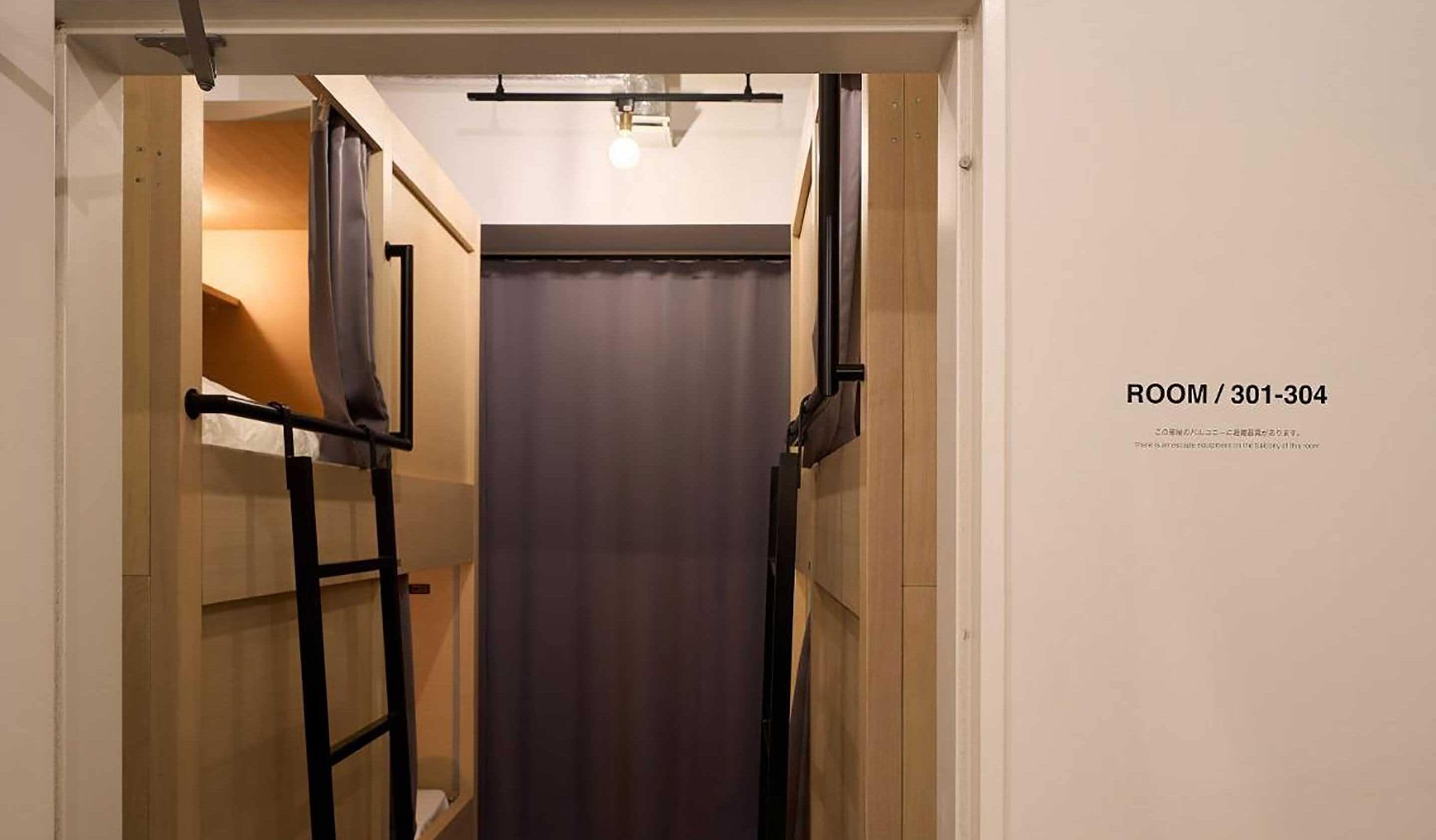 A narrow hallway with a door at the end, labeled ROOM / 301-304.