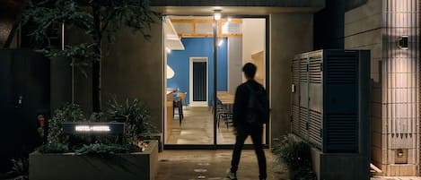 A hotel entrance at night with a person walking in.