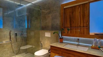 A modern bathroom with a glass-enclosed shower, a wooden vanity, and a large mirror.