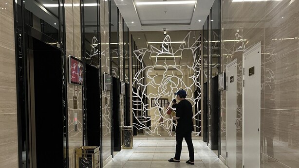 A modern hallway with glass doors, a marble floor, and a decorative wall art installation. - Vinhomes Gardenia - 2 Brs Apartment (Hanoi)