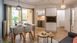 A modern living room with a dining area, kitchen, and a balcony with curtains. - Ermitage by Interhome (Hossegor)