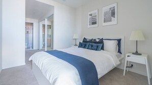 A modern bedroom with a large bed, two bedside tables, and a view of a hallway. - Stunning 1BD Haven with Panoramic City Views (Brisbane City)