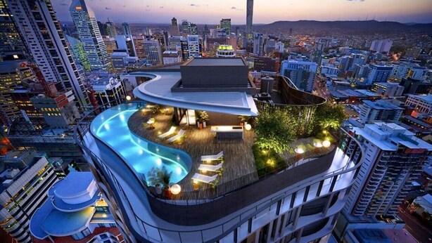 A high-rise building with a rooftop pool and outdoor seating area. - Stunning 1BD Haven with Panoramic City Views (Brisbane City)