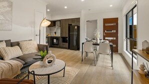 Un salon moderne avec un canapé, une table basse et un coin repas.