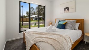 A bedroom with a bed, a ceiling fan, a window, and a framed picture on the wall. - Comfortable 3BR home/ Convenient location (Browns Plains)