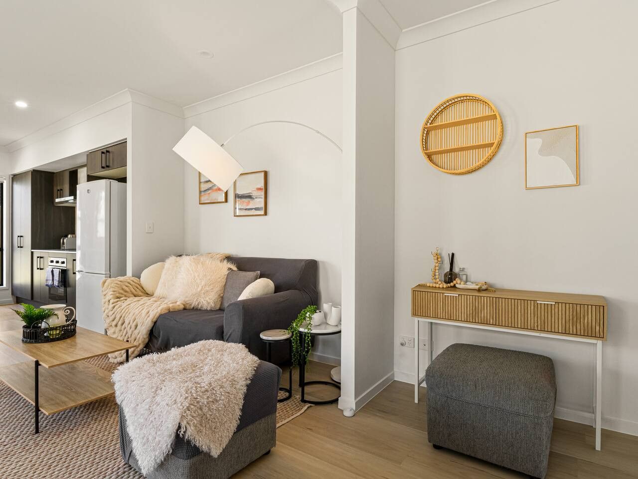 A modern living room with a grey sofa, a coffee table, and a side table with a plant.