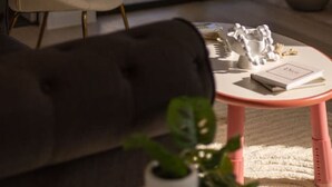 Un soggiorno moderno con un divano, un tavolino rotondo e una poltrona.